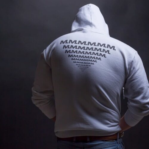 A man wearing a white hoodie with black writing on it.
